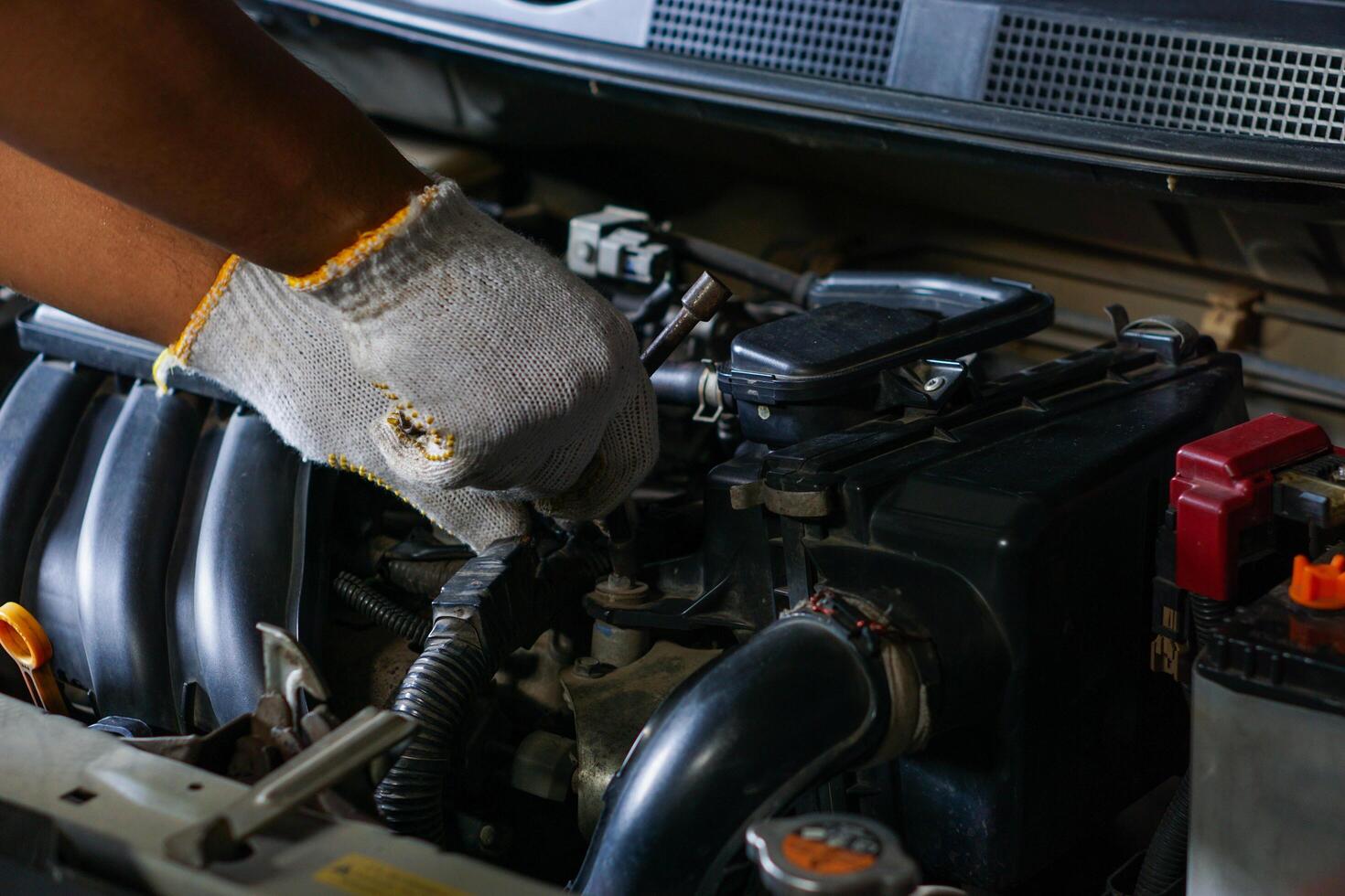a person in gloves is working on a car engine photo
