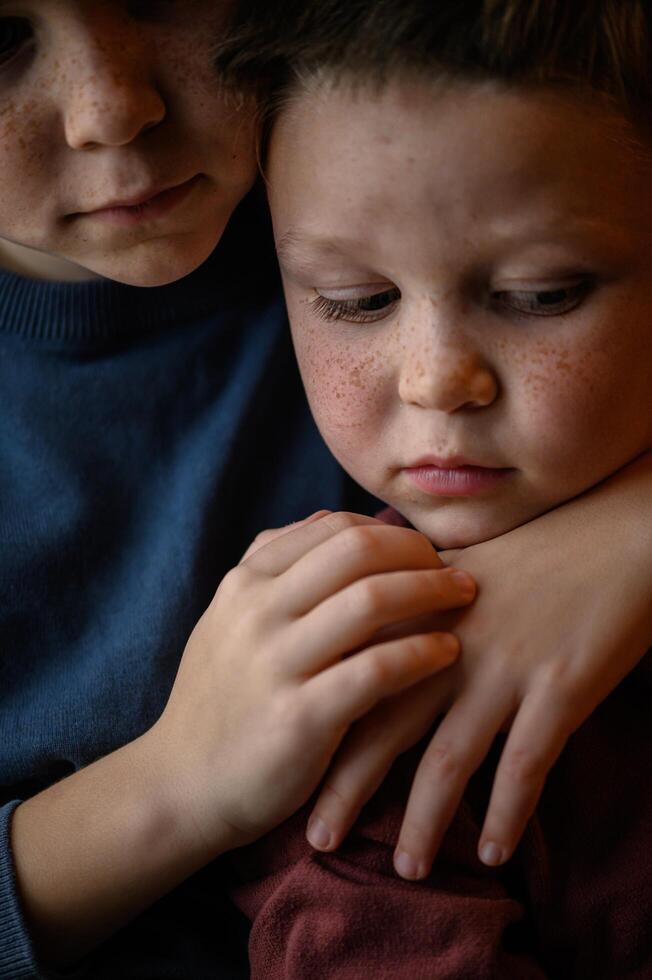 Two brothers with matching freckles smile warmly, their bond shining through their bright, expressive eyes. photo