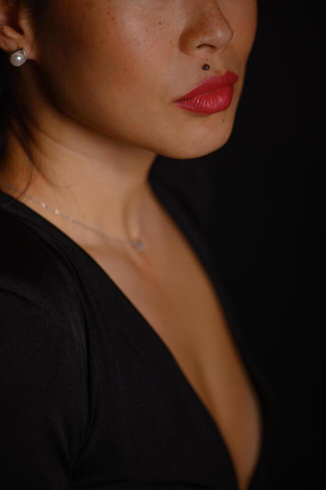An Asian woman poses gracefully in a studio, her expression calm and confident against a neutral backdrop. photo
