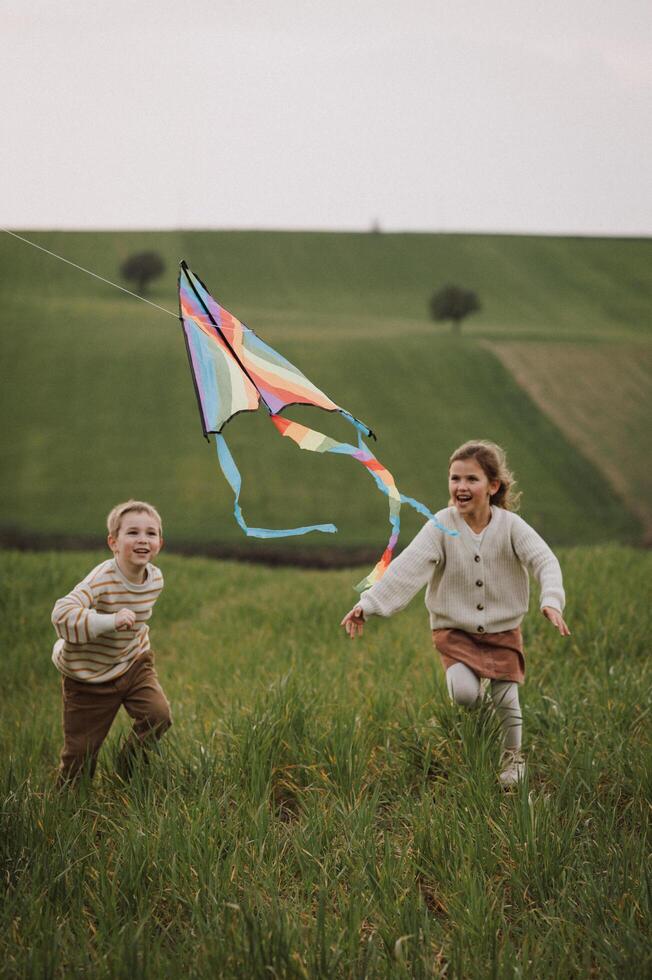 Wind in kids hair and joy in their hearts, they chase the kite with boundless energy. photo