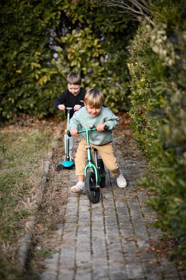 The scooter and balance bike race through the garden, their tiny riders beaming with joy and excitement. photo