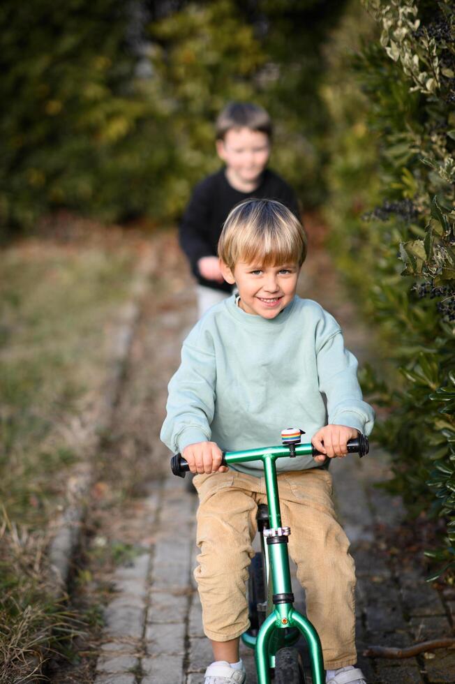 Two best friends on wheels, gliding through the garden, their eyes shining with pure childhood happiness. photo
