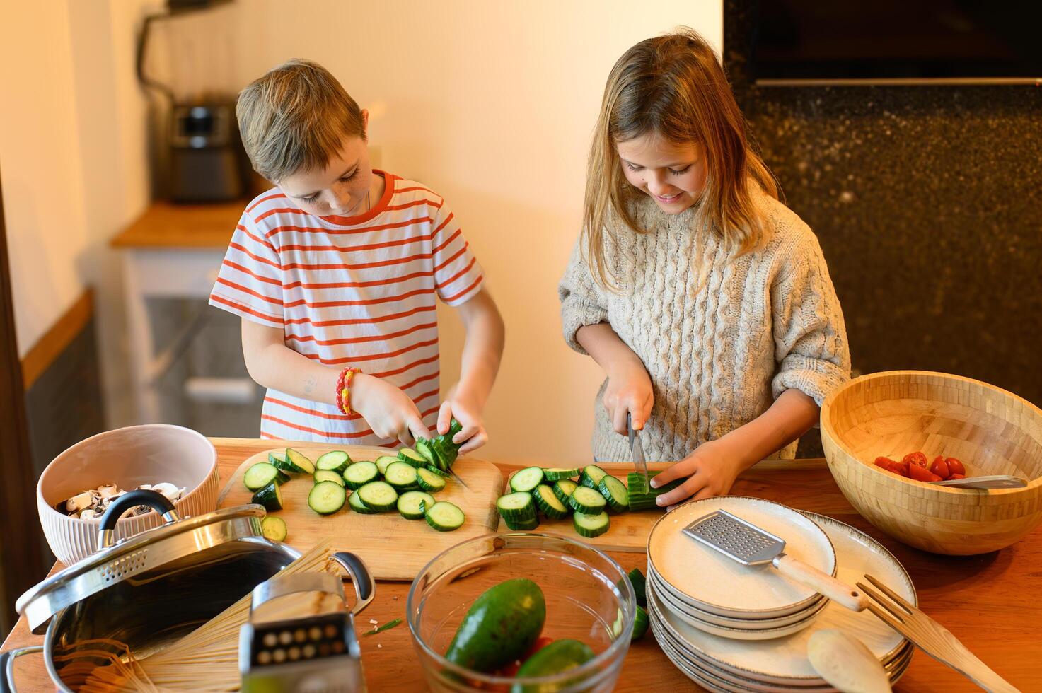 Childs laugh when a tomato slice falls off the board, enjoying the fun of cooking together. photo