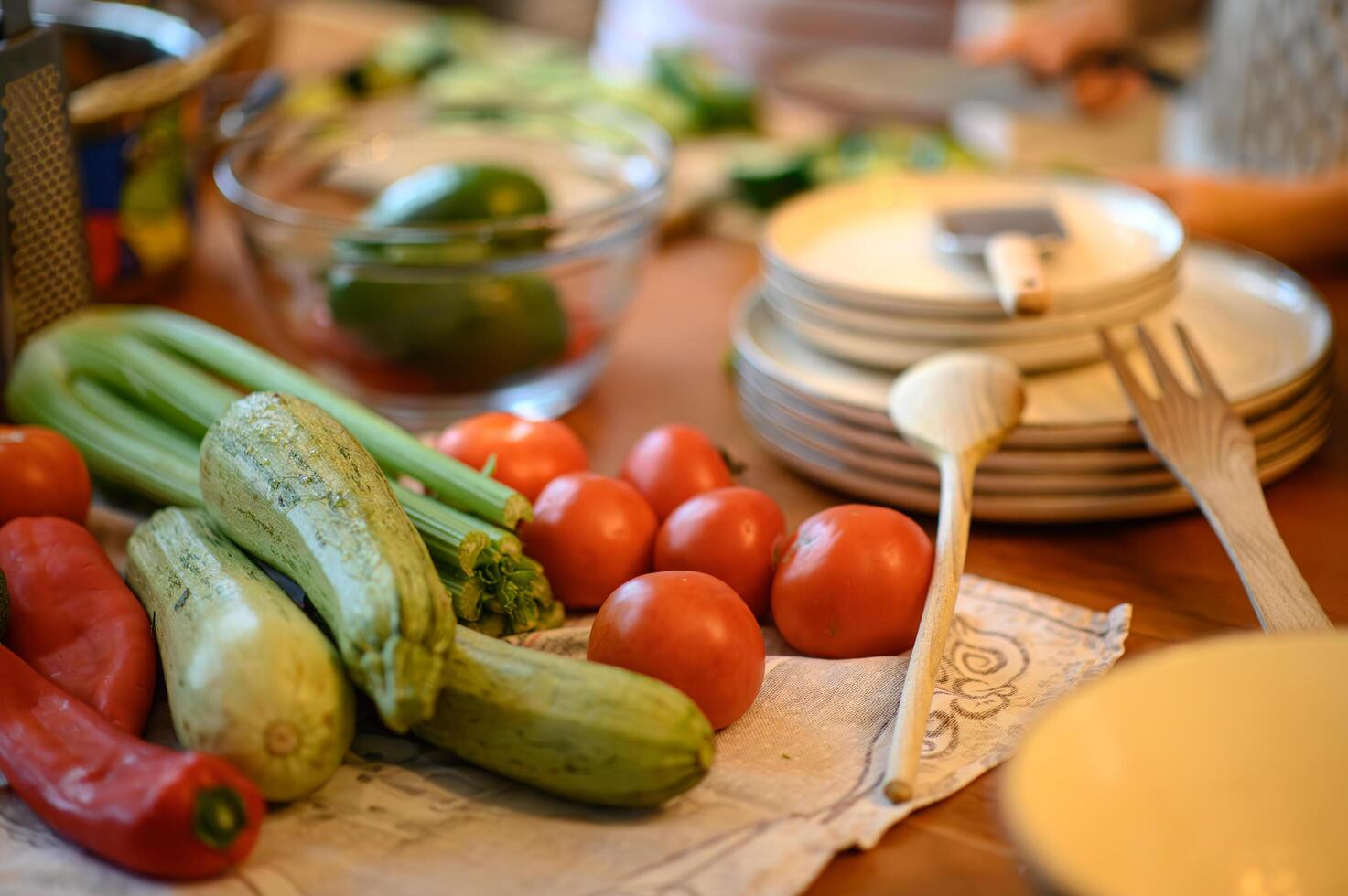 The table is covered with bright, fresh produce lettuce, avocados, carrots, and more. photo