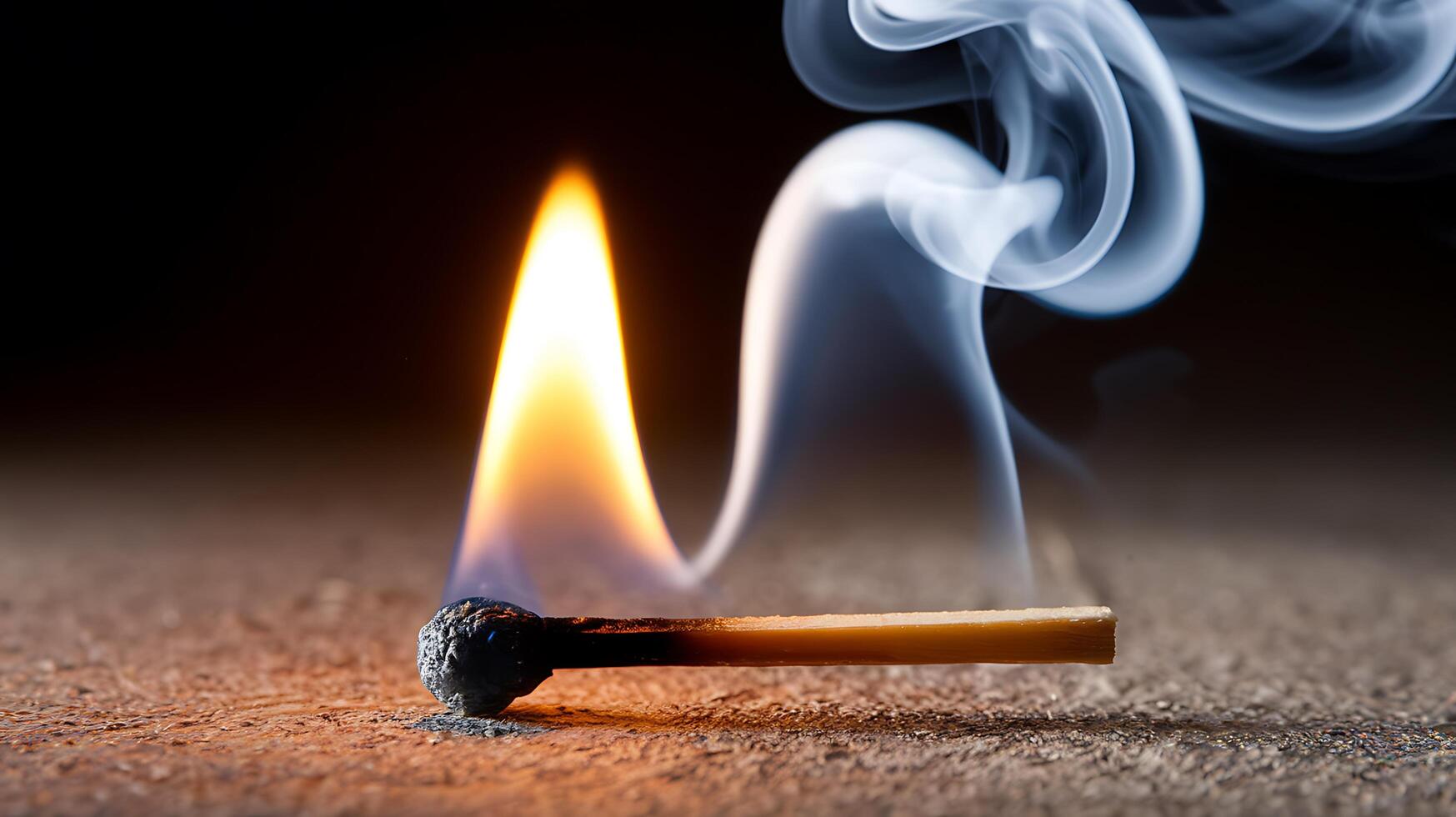 A matchstick with a burning match on the ground photo