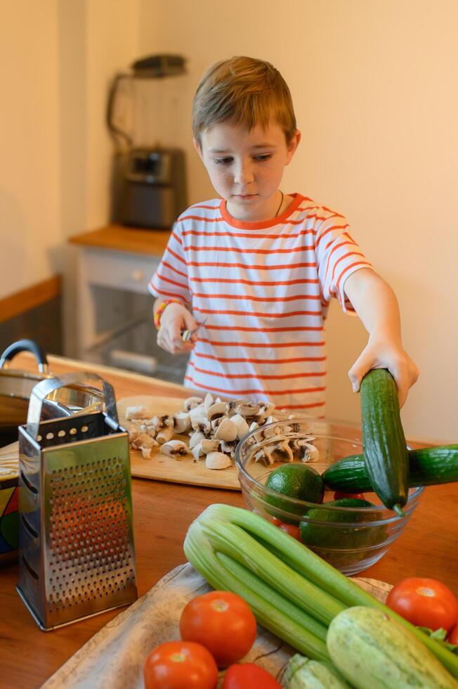 He smiles as he places the last slices into the bowl, feeling proud to help prepare a healthy and delicious salad. photo