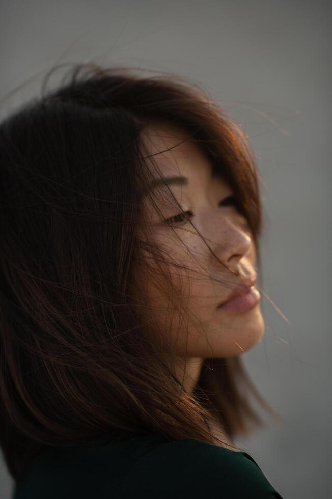 Her peaceful expression and warm sunset tones create a mesmerizing and dreamy portrait. photo