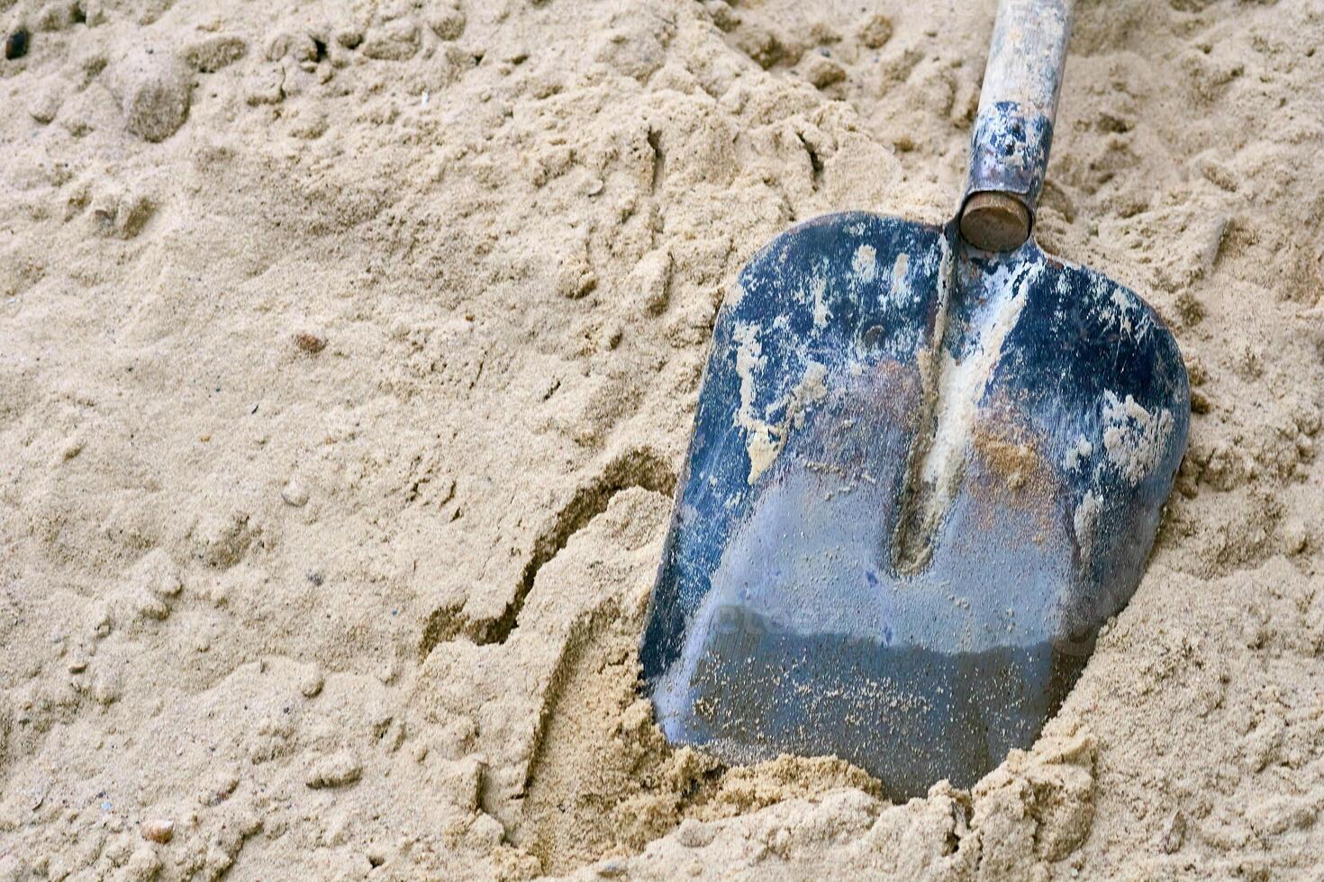 Working shovel in a pile of sand at a construction site photo