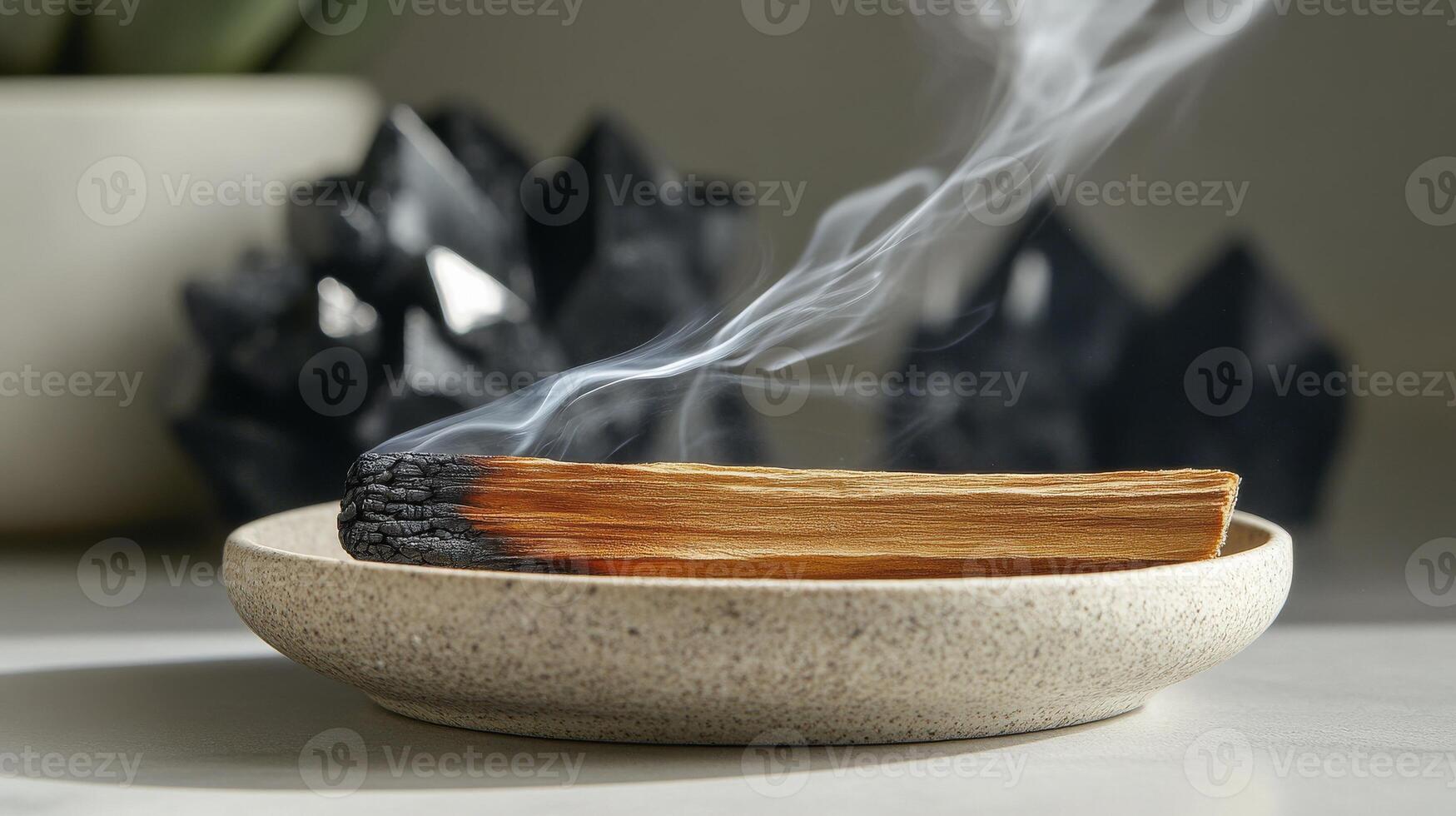 A smoldering palo santo stick in ceramic dish. Black tourmaline and celestite gemstones. Healing and spiritual ritual photo