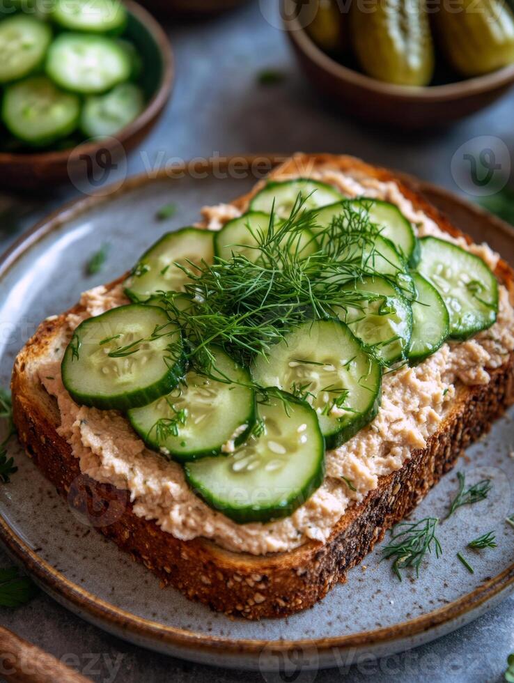 Cucumber and dill open-faced sandwich with creamy spread on whole grain bread photo
