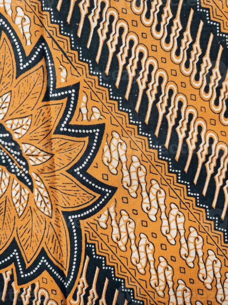 a close up of a black and orange fabric with a flower design photo
