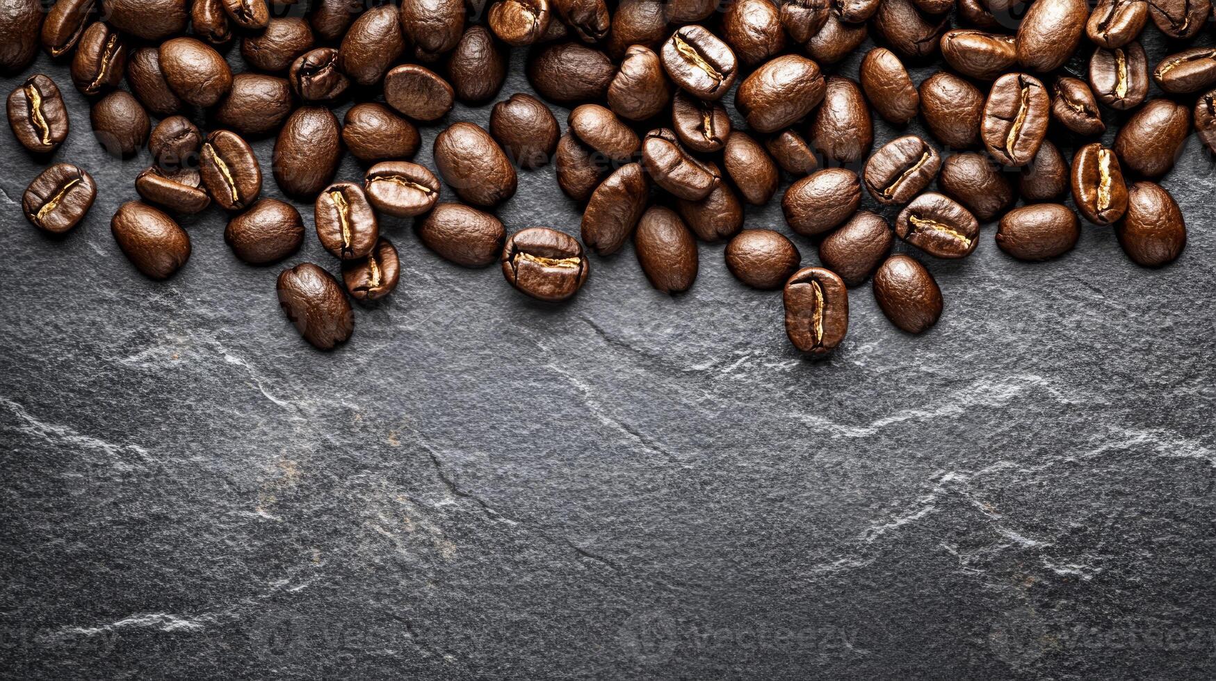 A stunning top view of coffee beans scattered on a grey slate background, showcasing their rich texture and inviting aroma. This image is perfect for coffee lovers and brewing enthusiasts photo