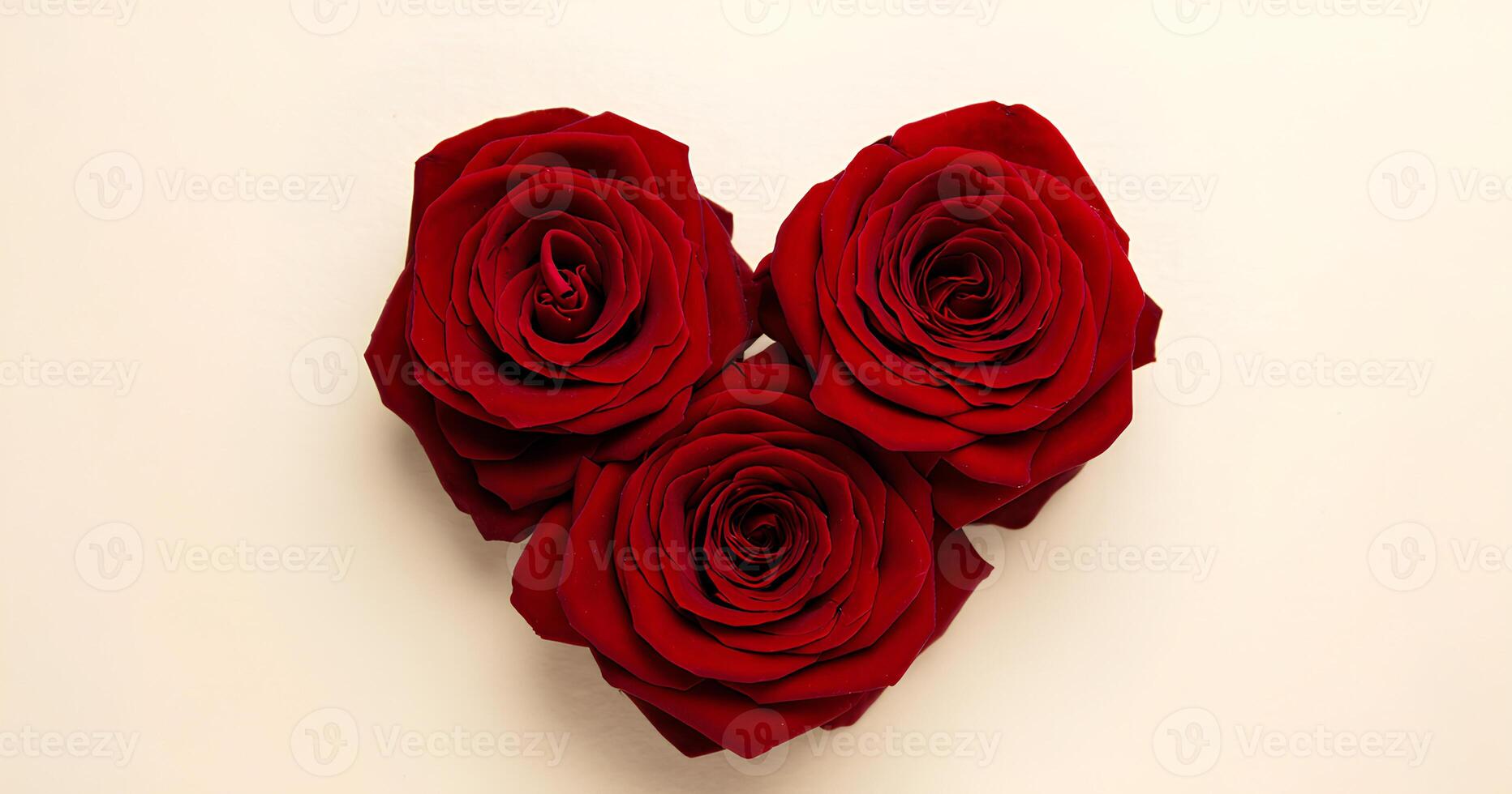 Three Red Roses Arranged in a Heart Shape on a Light Beige Background photo