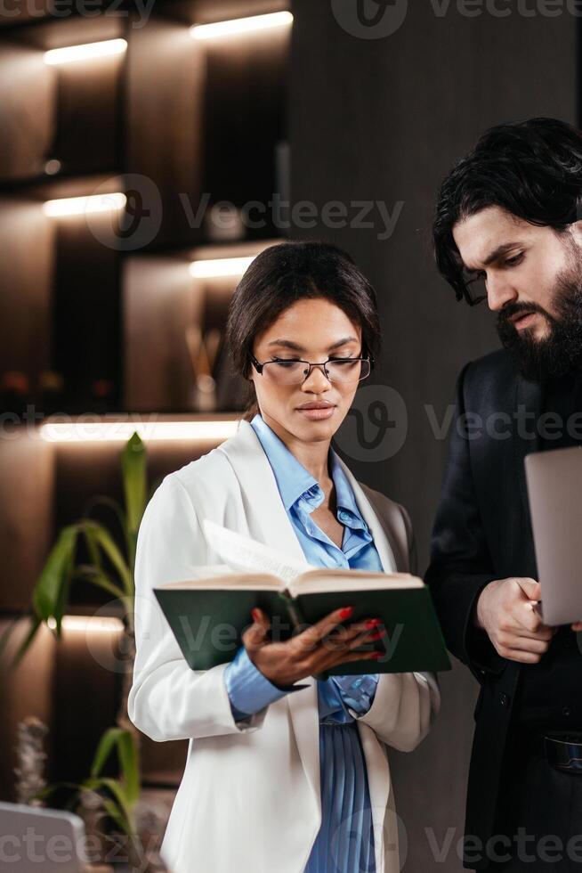 Legislation, legal education concept. African American Businesswoman reading law books to advice client. Statute of limitations. Attorney Fight for Freedom of Her Client with Supporting Evidence photo
