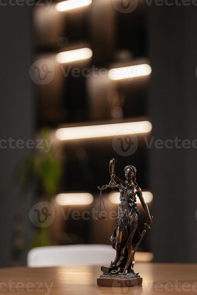 Golden lady justice statue is displayed on a wooden desk in a law office, symbolizing justice, fairness, and the legal system. Statue of Themis with a pair of scales of justice. Vertical shot photo