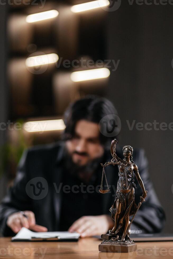 Statue of Justice with scales and a lawyer working on a laptop. Concept legal consultations and decision-making using modern technology for efficient legal solutions photo