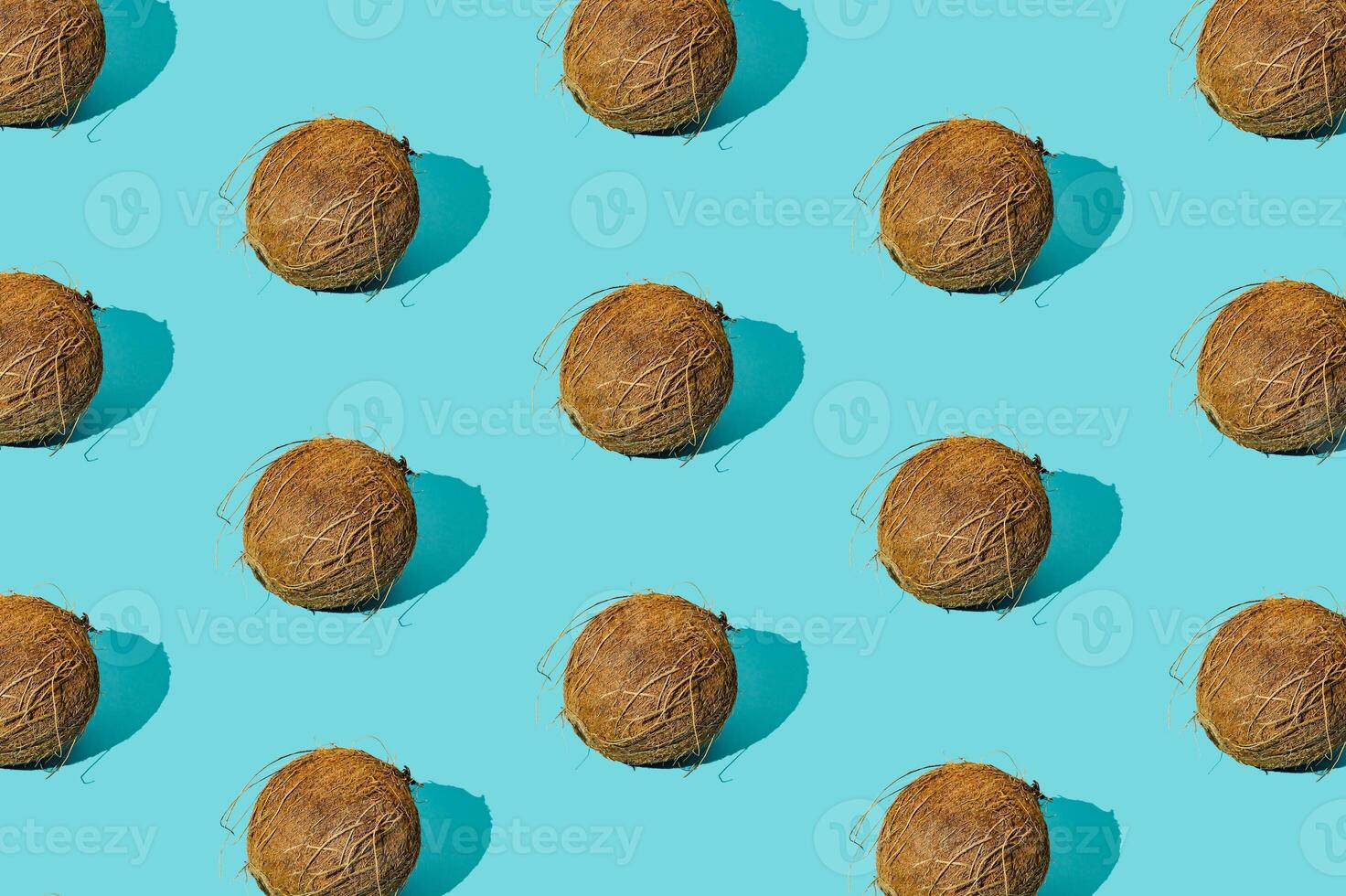 Trendy sunlight summer fruit pattern made of coconuts on light blue background. Nature summer concept. Coconut aesthetic. photo
