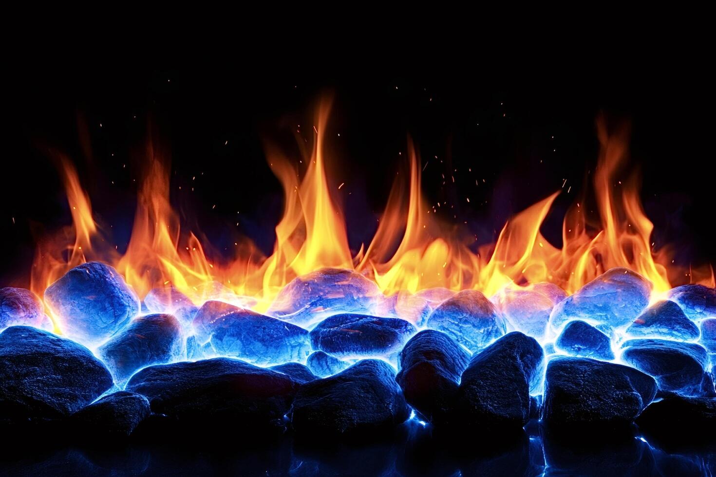 Vibrant flames rising from glowing blue rocks in the dark photo