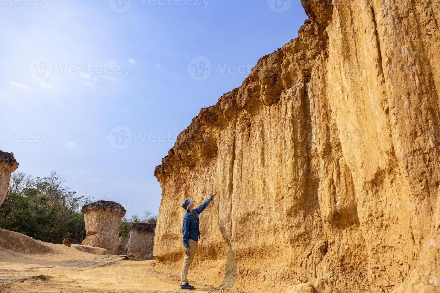 Asian geologist is exploring and measuring the sample rock on the natural sandstone canyon quarry resource site for scientific research and archeology for understanding mother earth photo