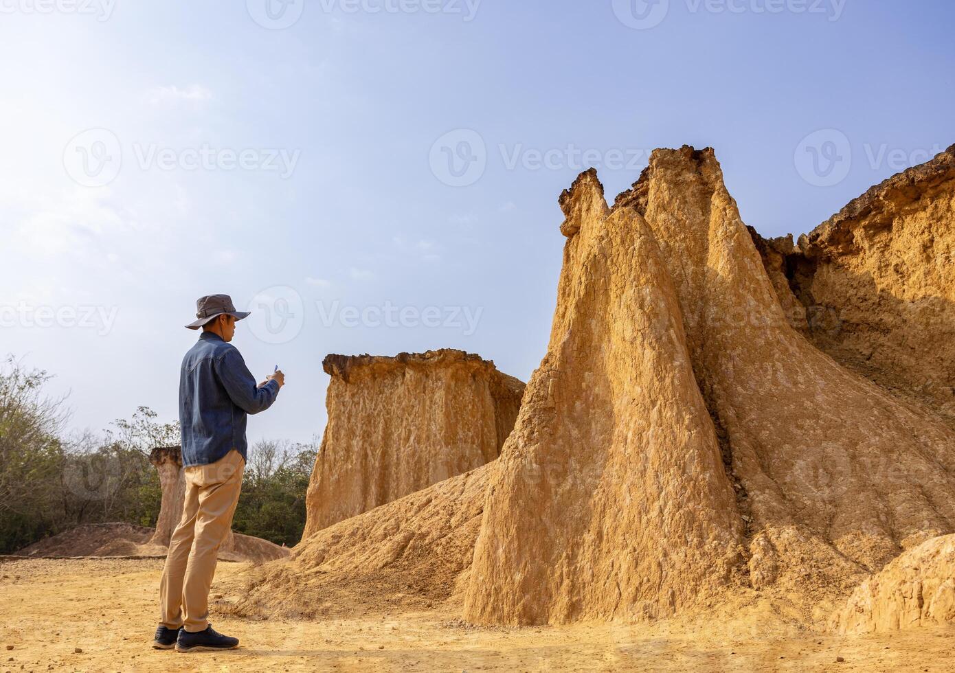 Asian geologist is exploring and surveying on the natural sandstone canyon quarry resource site for scientific research and archeology for understanding mother earth photo