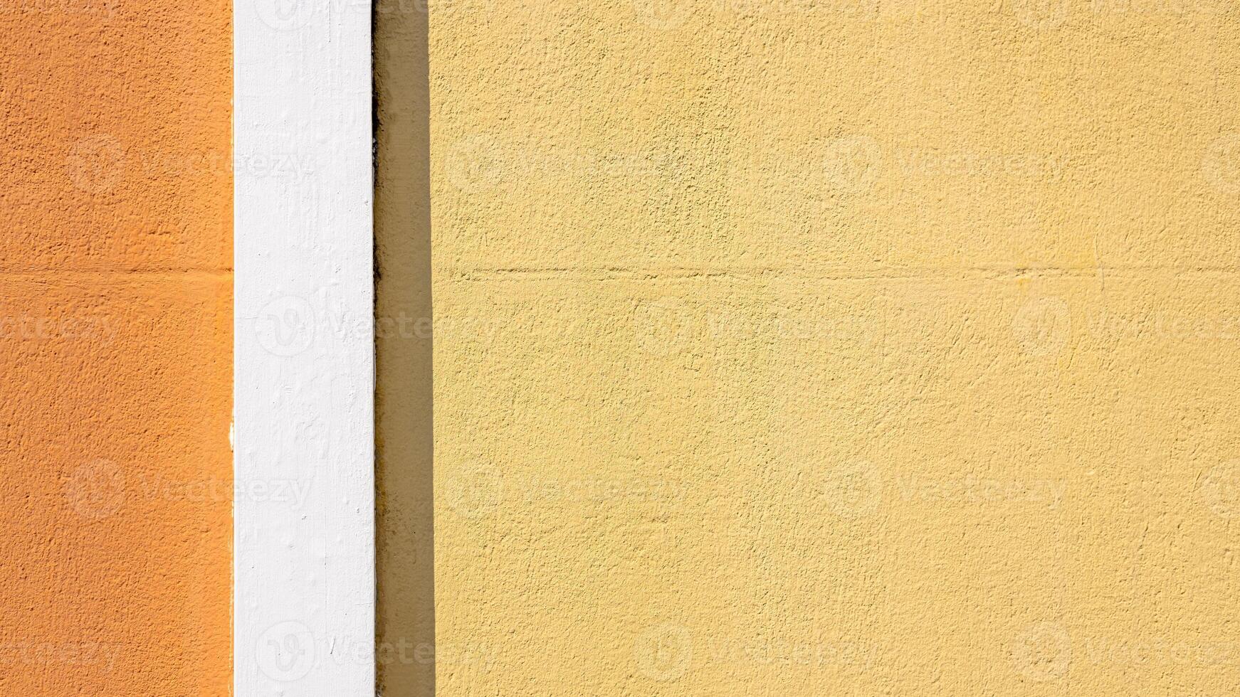 Pastel yellow cement wall of house building, White cement wall with yellow orange contrast with sunlight and shadow on the surface of background, Exterior architecture design concept of house. photo