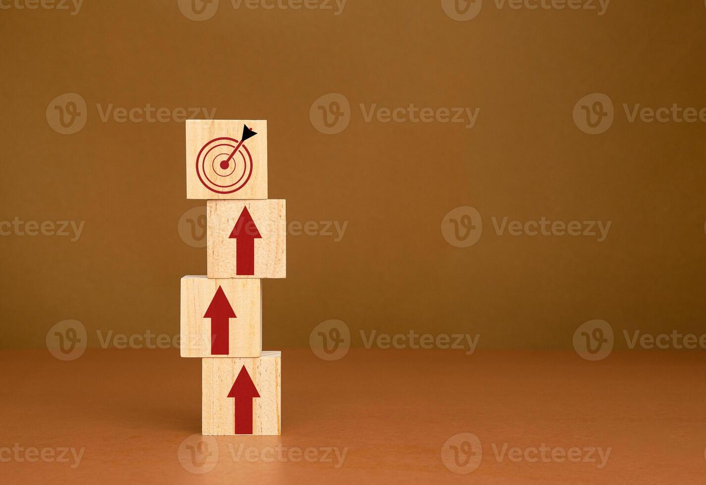 Wooden blocks stacked with red arrows point to the dartboard icon on a brown background photo
