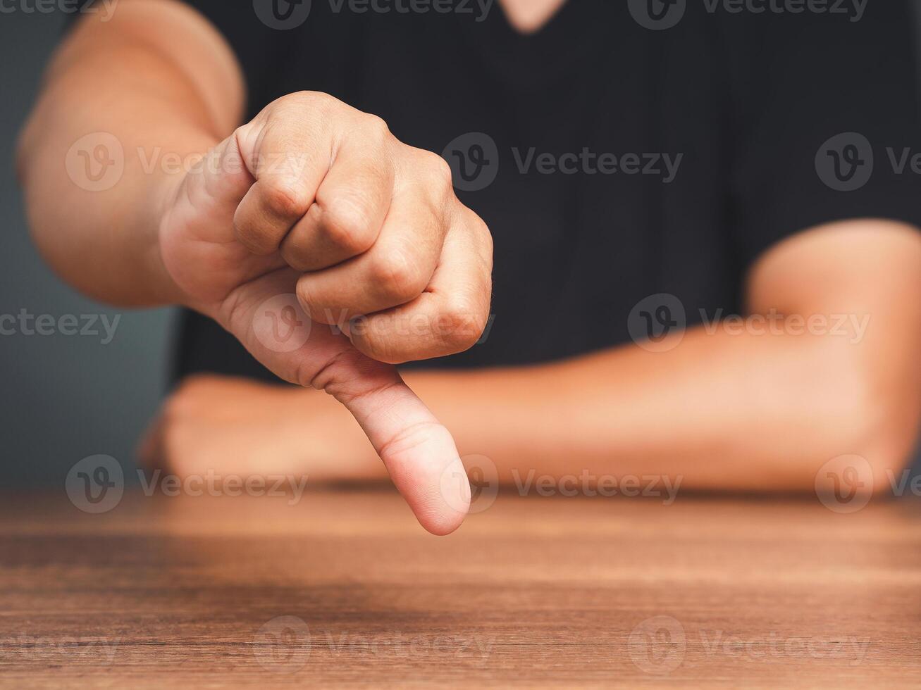 Close-up of young man's hand showing a thumbs down for dislike service photo