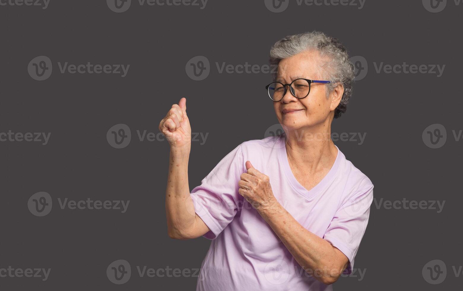 Senior woman showing hands up and looking away with a smile photo