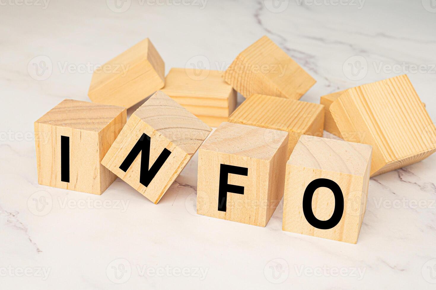 Wooden cubes with letters INFO over a marble table photo