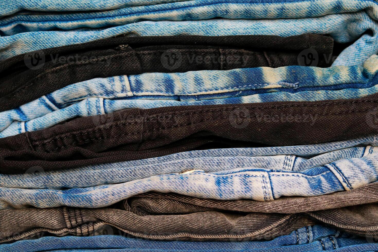 A stack of jeans on the shelf in the store. Close up photo
