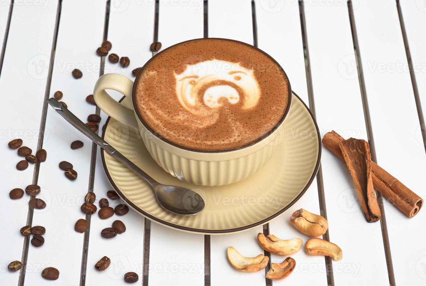 Cup of nut cappuccino with spoon and sugar on wooden white table side view photo