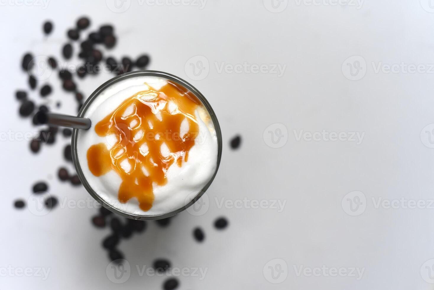 Ice caramel latte with coffee beans isolated on white background top view closeup photo