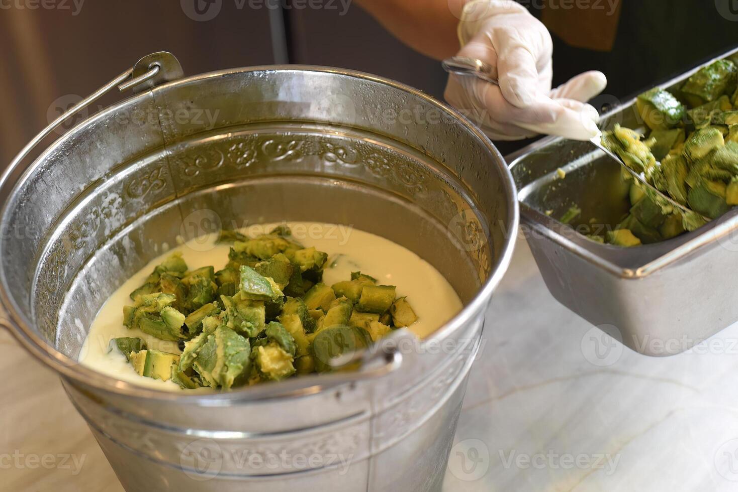 Base of ice cream with avocados and spoon close up photo