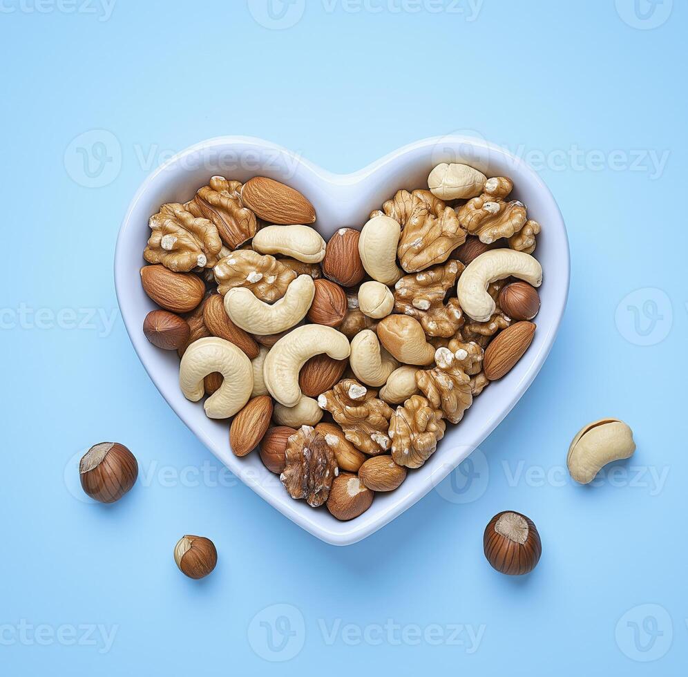 heart shaped bowl filled with mixed nuts including cashews, almonds, and walnuts, perfect for healthy snack or decoration photo