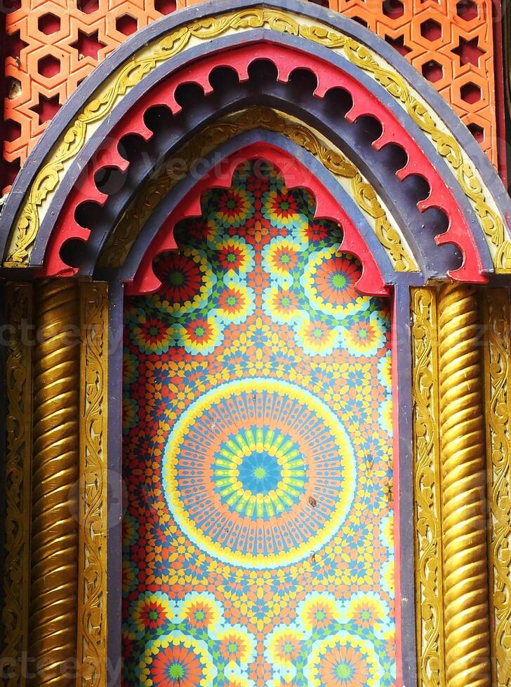 Traditional building of an asia ethnic pattern design background. Colorful design with a yellow circle in the center. The circle is surrounded by a pattern of flowers and leaves photo