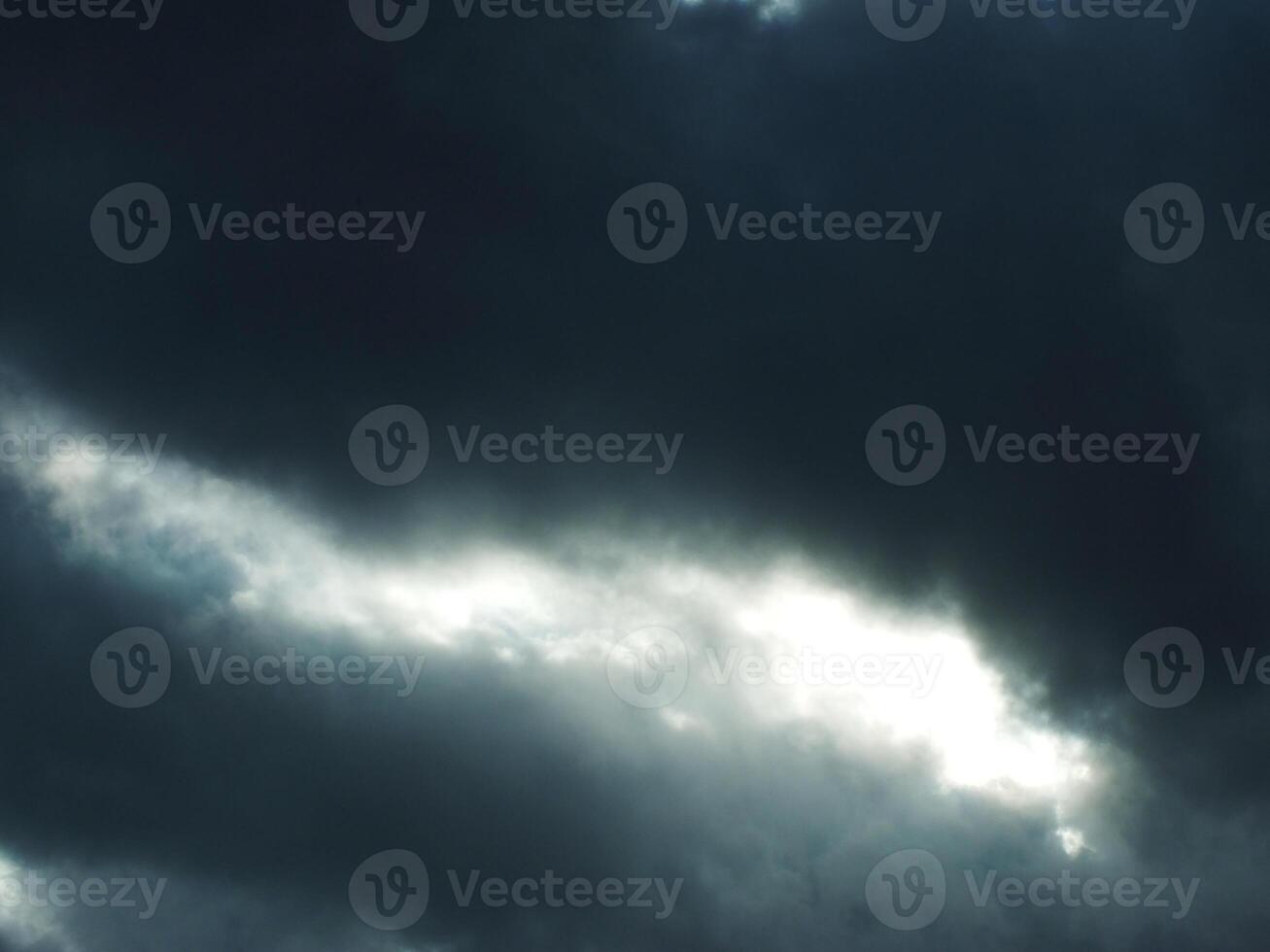 The dark sky was overcast and cloudy, with a little sunlight peeking through the clouds. A sign of a rainstorm. The scene is gloomy and somewhat melancholic photo
