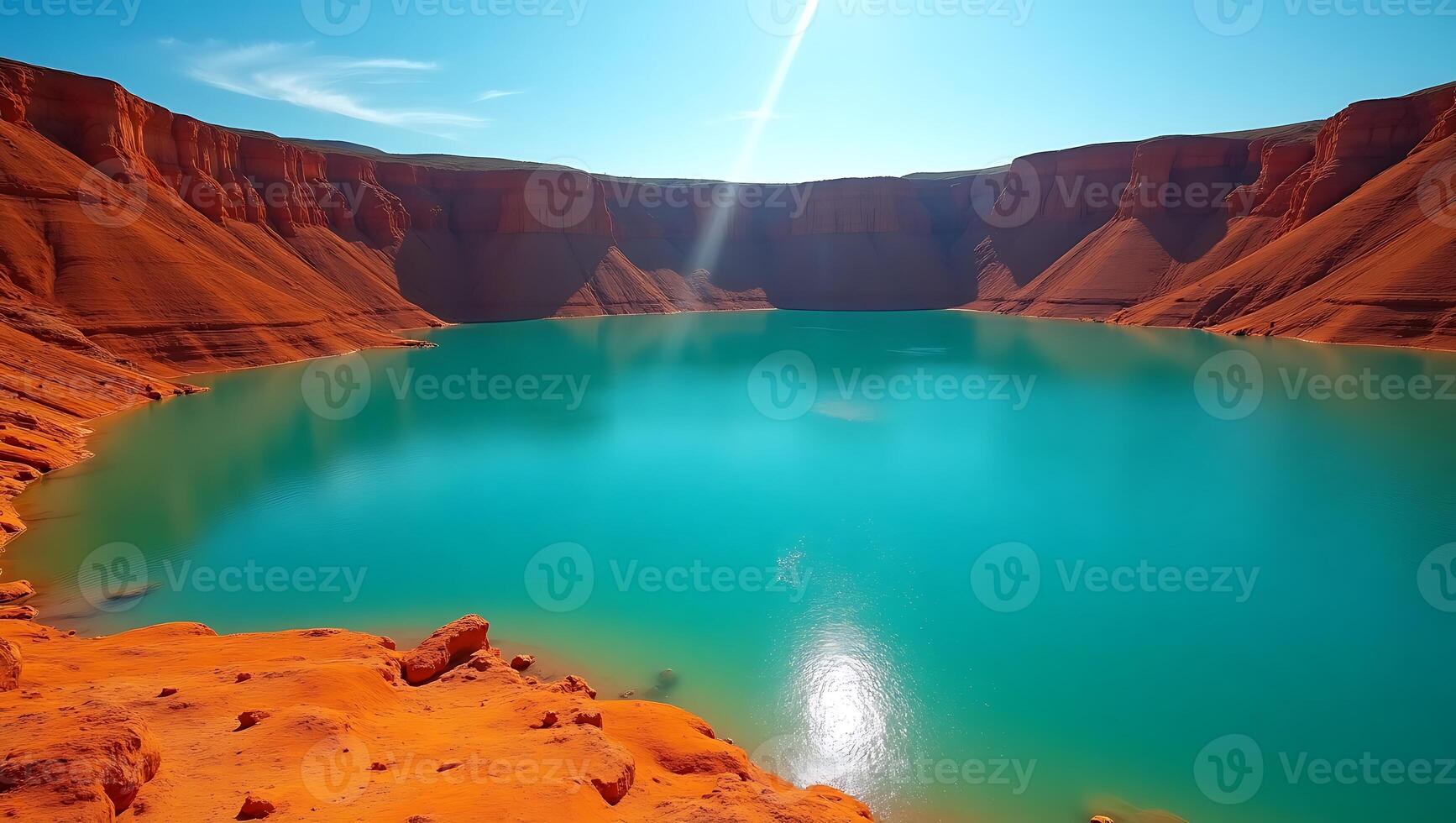 Beautiful turquoise lake surrounded by red cliffs under clear blue sky photo