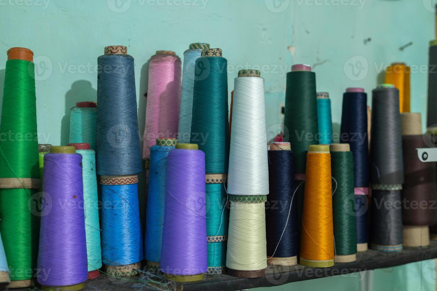 Spools of thread standing on a shelf photo