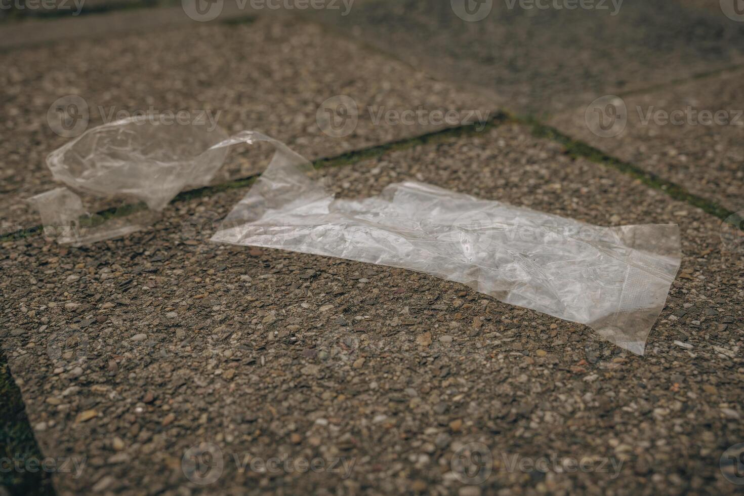 Plastic waste discarded on the ground at a public space in the city during the afternoon photo