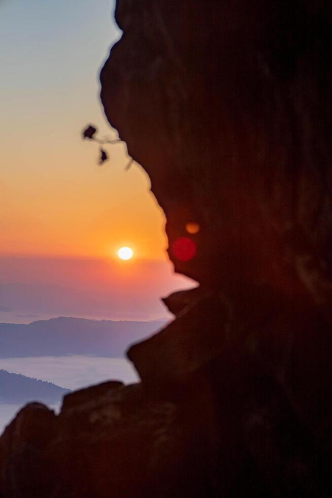 The cliff shows the fog as the sun rises over the golden sky in the background. Thailand. Rainforest. Bird's eye view. Aerial view. photo