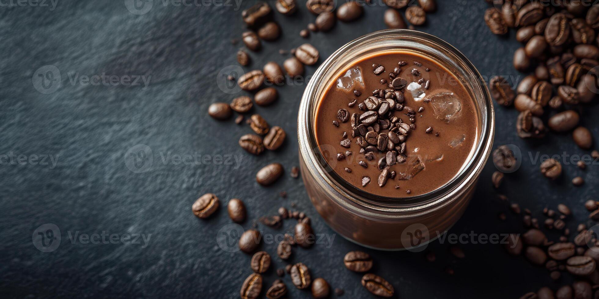 Delicious chocolate coffee drink served in a glass jar with coffee beans scattered on a dark surface photo