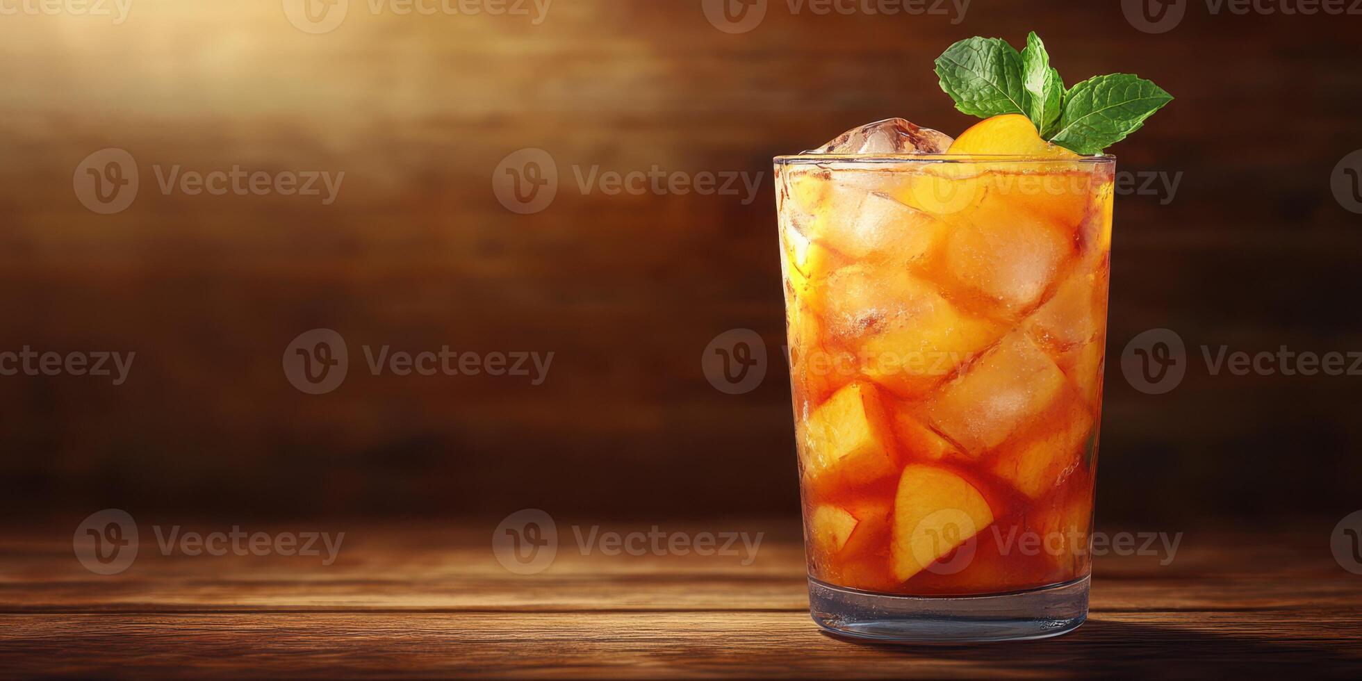 Refreshing iced tea with fruit and mint served in a tall glass on a wooden table photo