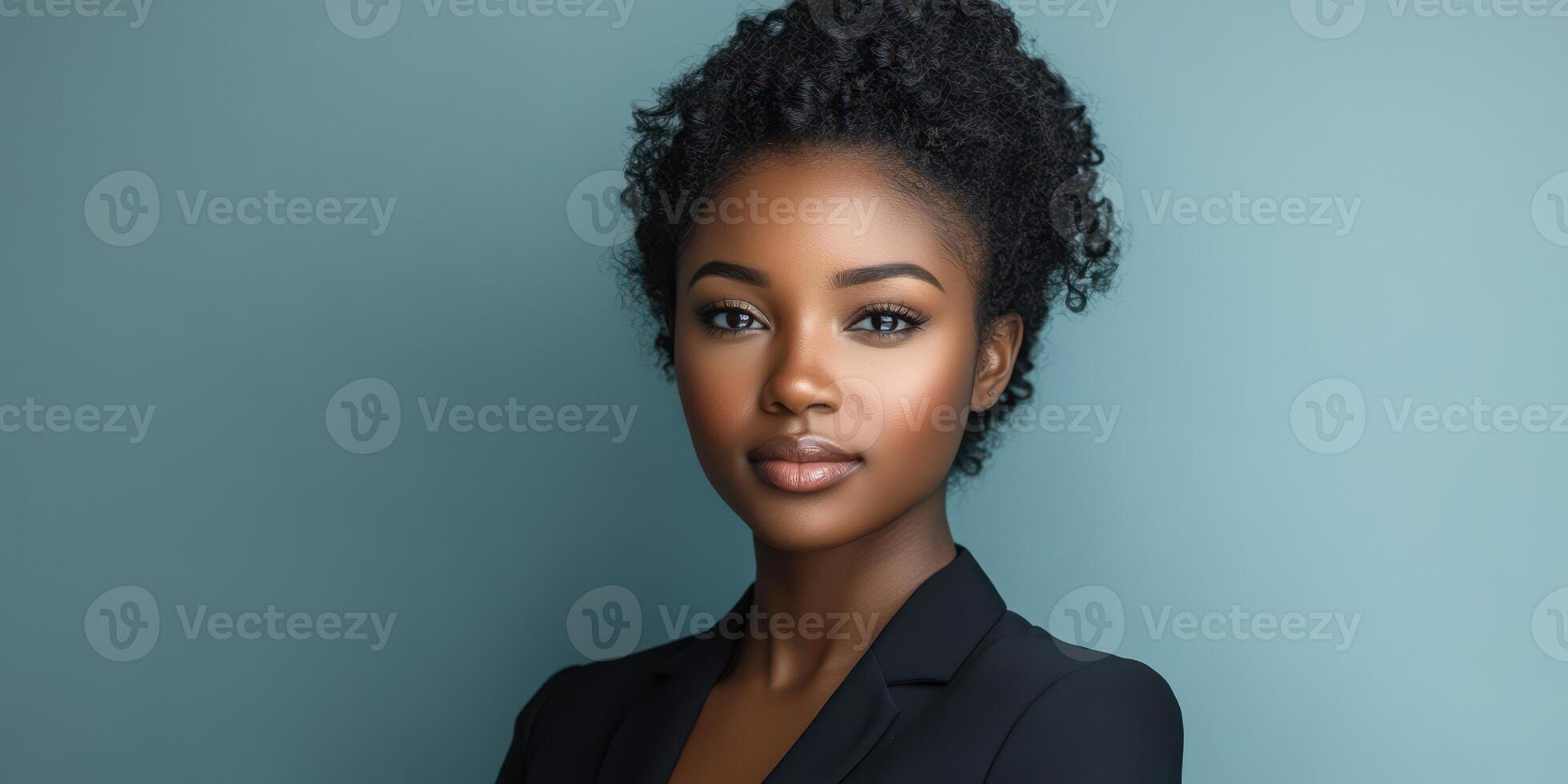 Portrait of a young woman with textured hair wearing a black blazer against a solid blue background in a professional setting photo