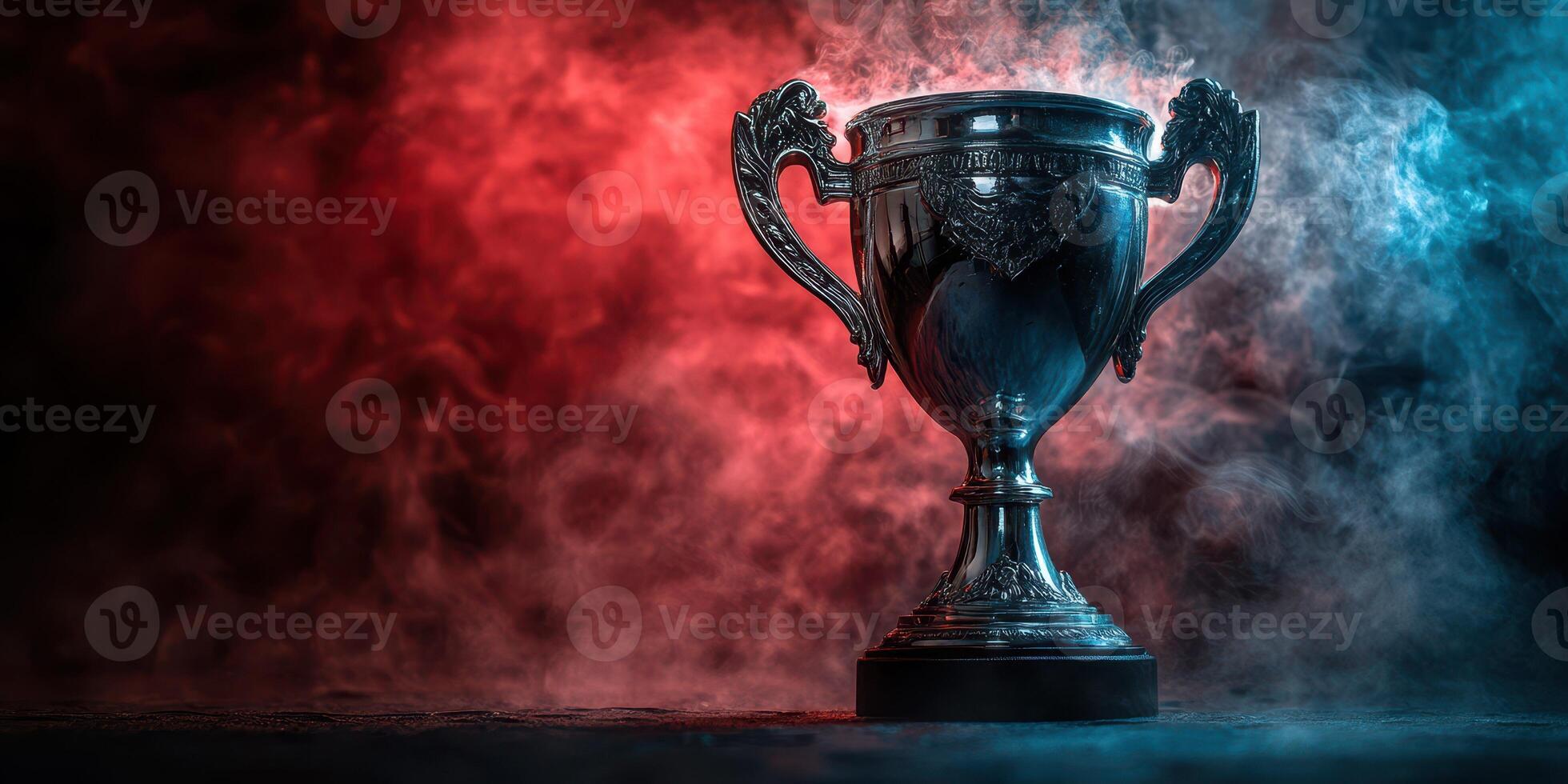 Shiny silver trophy on a dark background illuminated by vibrant blue and red smoke during a competitive event photo