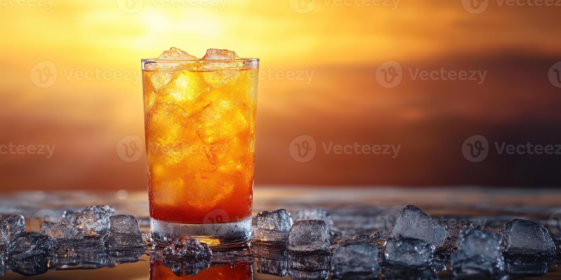 Refreshing summer drink served in a clear glass with ice against a vibrant sunset backdrop over the ocean photo