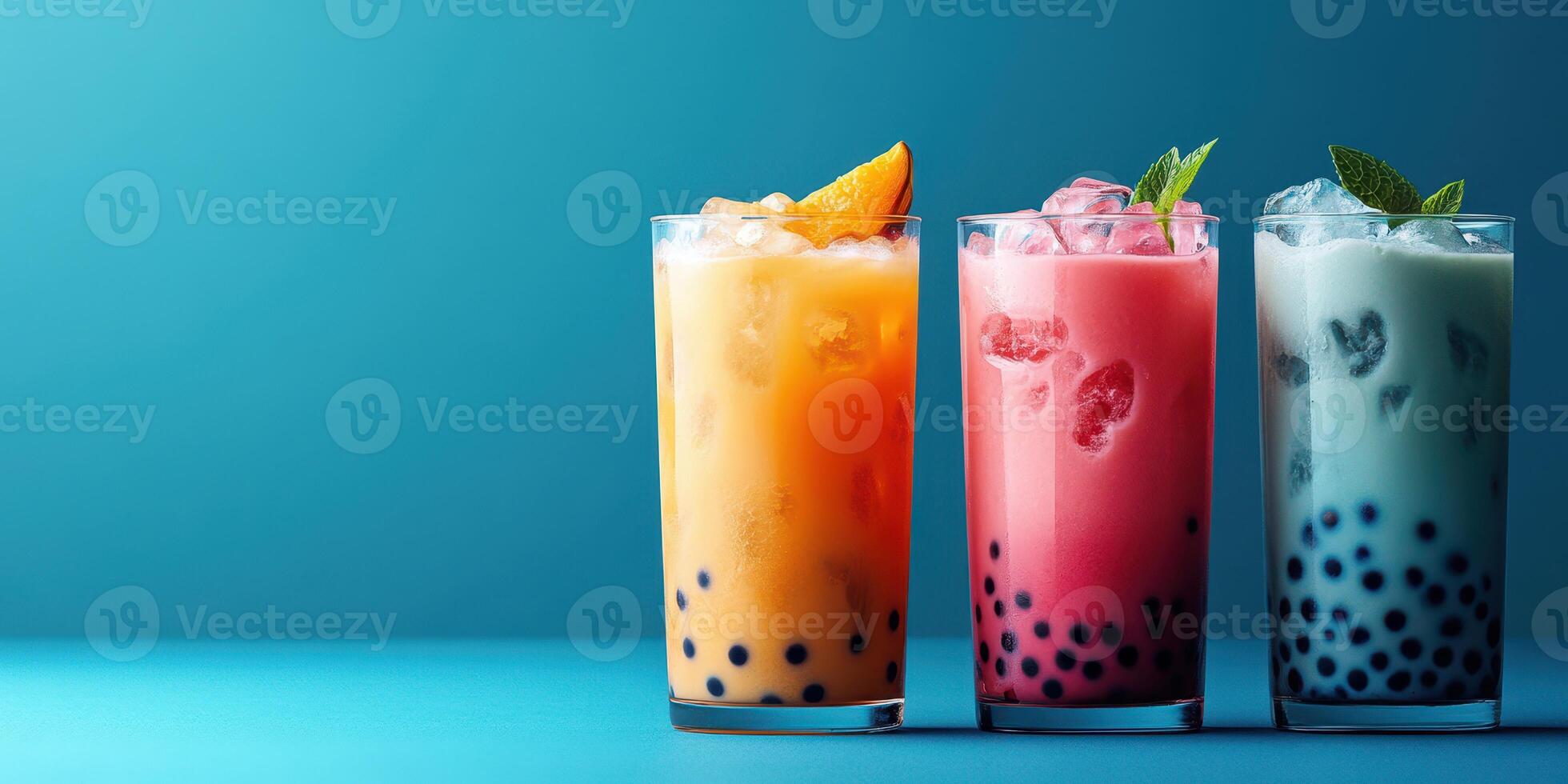 Colorful bubble tea drinks on a vibrant blue background with ice and garnishes photo