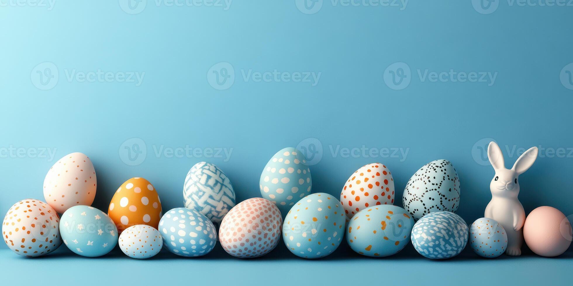 Colorful decorated eggs and a ceramic bunny arranged on a blue background for spring celebration photo