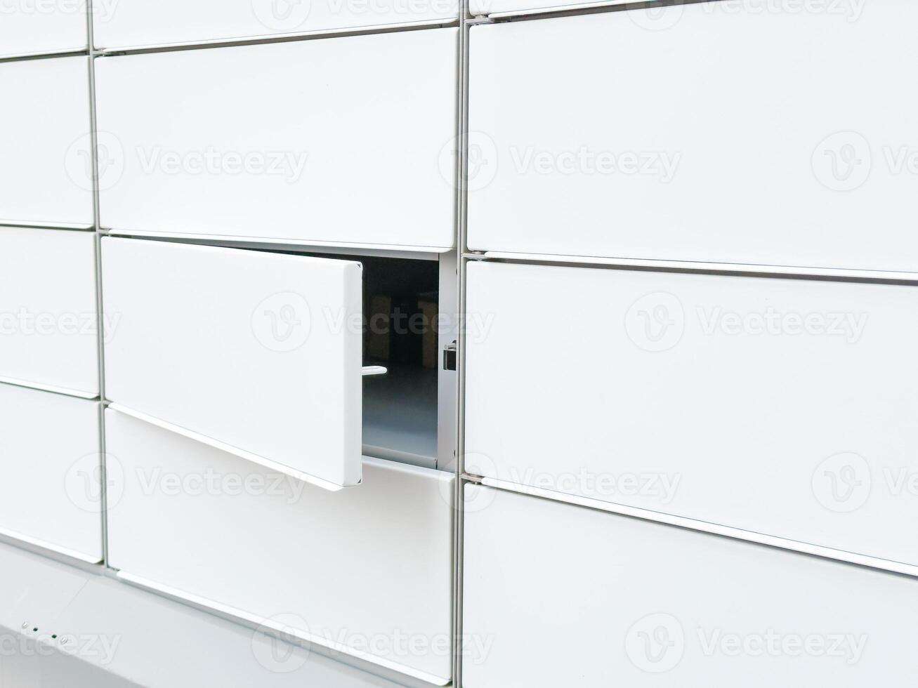 Open locker in a modern white parcel locker system for delivery and storage photo