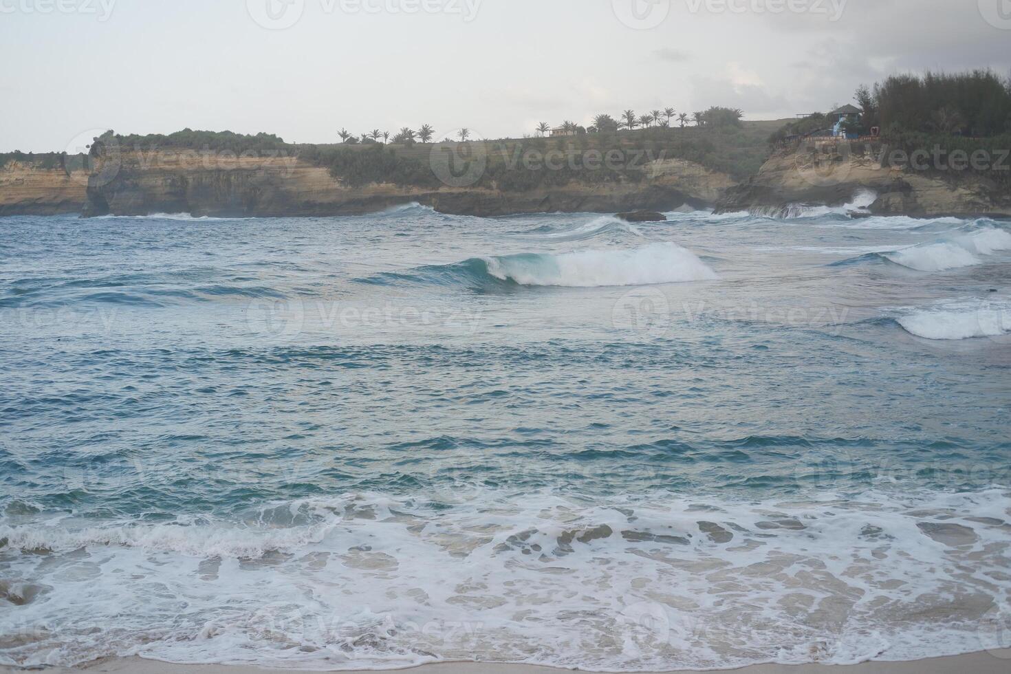 Serene Waves Crash on the Rocky Shore photo