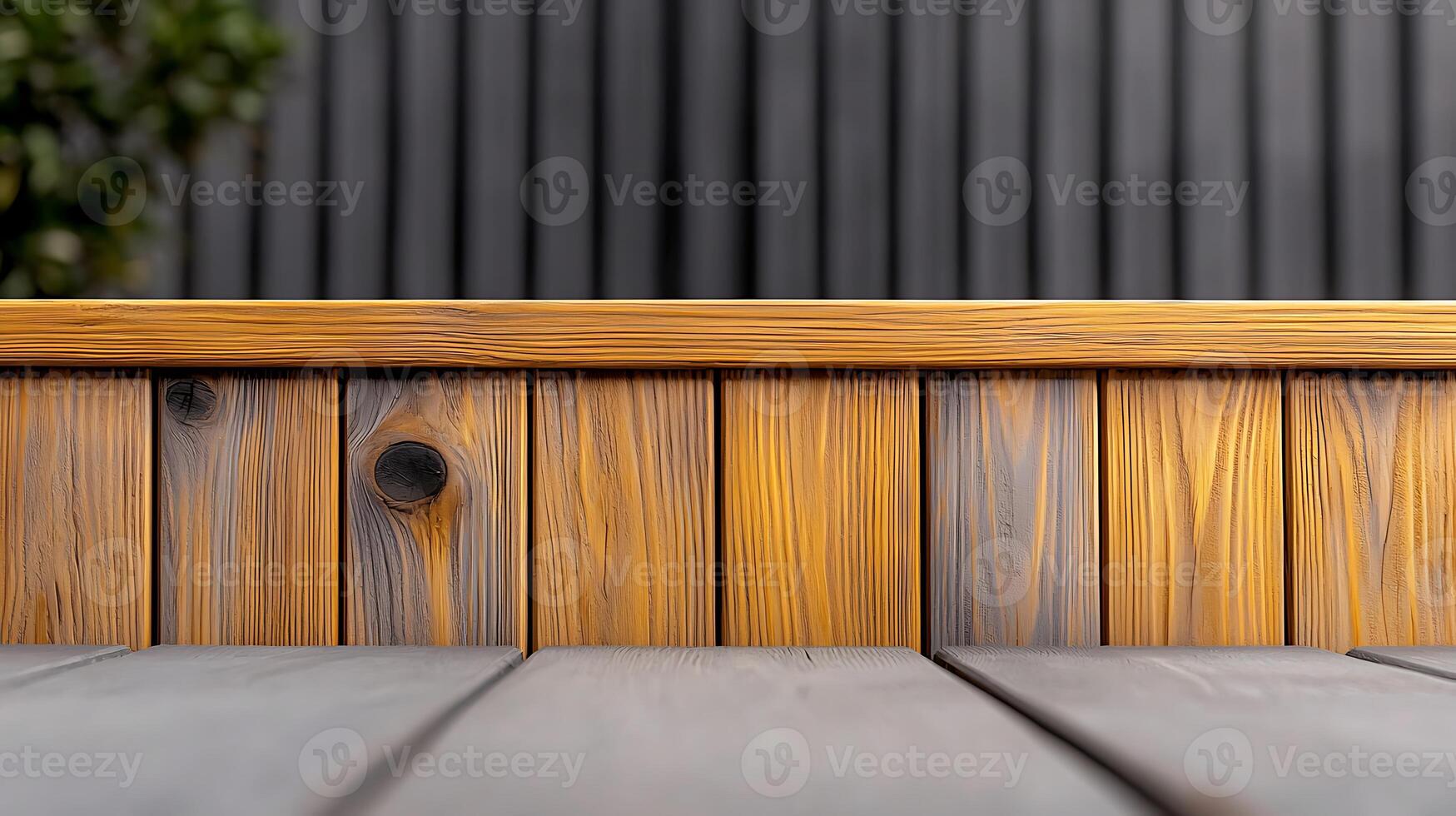 Close-up view of a wooden surface with natural grain patterns, framed by a blurred garden backdrop photo